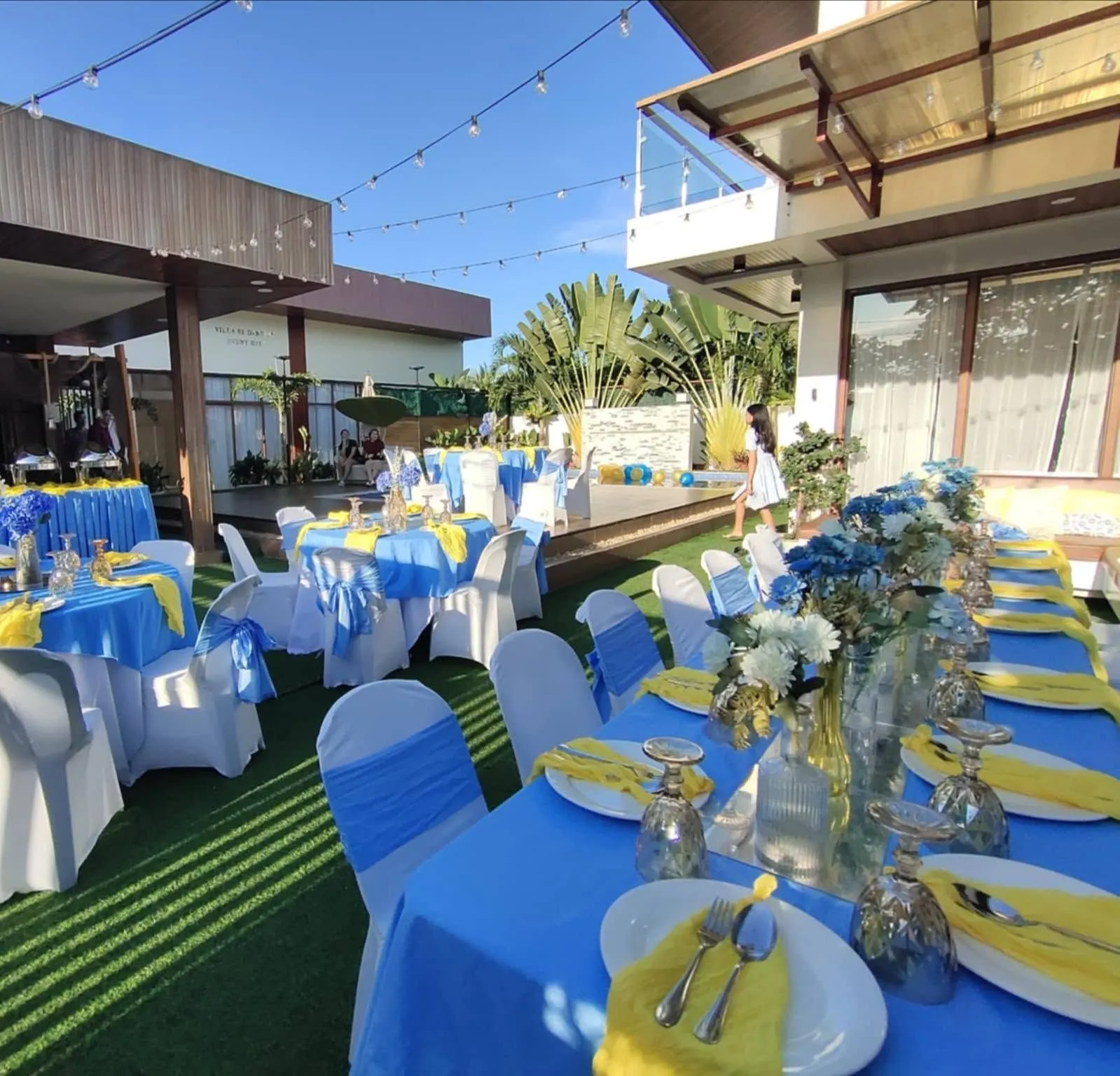 Blue and yellow outdoor set-up on the lawn beside the villa